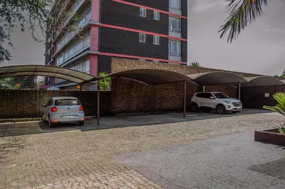 two cars parked in a parking lot in front of a building at 18 Churchill Avenue in Witbank