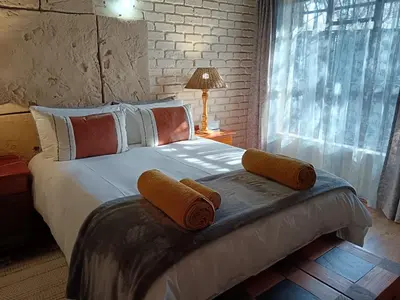 a bedroom with a bed with two towels on it at Kifaru - Kruger in Marloth Park