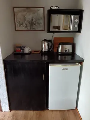 a kitchen with a black counter and a white refrigerator at Kifaru - Kruger in Marloth Park
