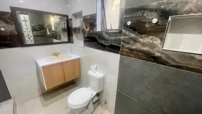 a bathroom with a toilet and a sink at Central Perk Guesthouse in Pretoria