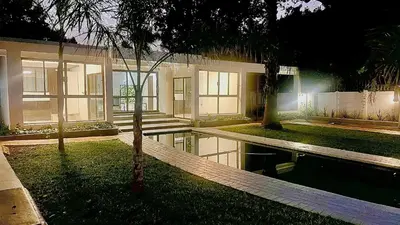 a house with a swimming pool in front of it at Central Perk Guesthouse in Pretoria