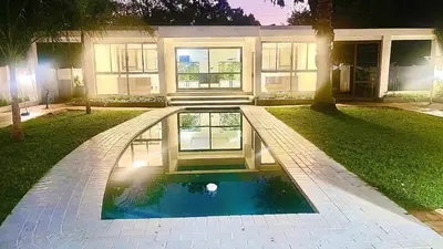 a house with a pool in front of a house at Central Perk Guesthouse in Pretoria