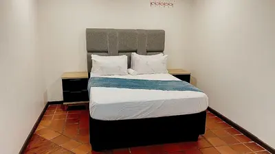 a bedroom with a bed with a large headboard at Central Perk Guesthouse in Pretoria