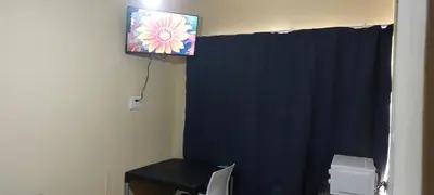 a tv hanging on a wall with a black curtain at Rest at 54 Gladiator Guesthouse in Kempton Park