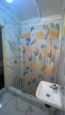 a bathroom with a shower and a sink at Rest at 54 Gladiator Guesthouse in Kempton Park