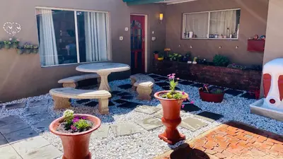 a patio with potted plants and a table and bench at Micnels B & B in Pretoria