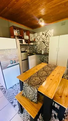 a kitchen with a wooden table with a bench at Micnels B & B in Pretoria