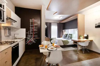 a room with a kitchen and a bedroom with a bed at Akanani Apartments in Pretoria