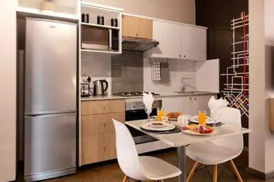 a kitchen with a table and chairs and a refrigerator at Akanani Apartments in Pretoria