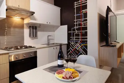 a kitchen with a table with two glasses of wine at Akanani Apartments in Pretoria