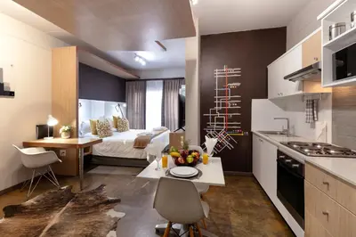 a room with a kitchen and a bedroom with a bed at Akanani Apartments in Pretoria