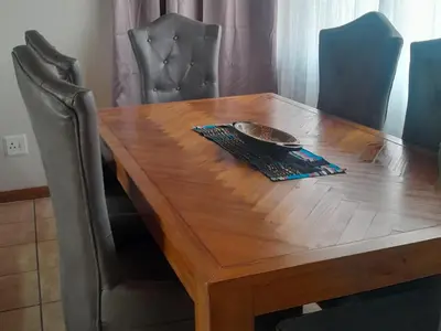 a wooden table with chairs and a bowl on it at 2 bedroom family friendly cosy & luxury home, walking distance to Doringkloof Mall in Centurion