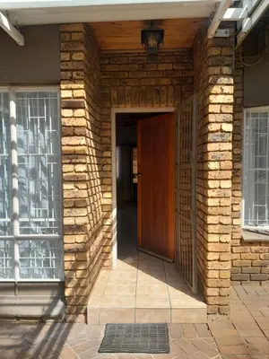 a brick building with a brown door and a window at 2 bedroom family friendly cosy & luxury home, walking distance to Doringkloof Mall in Centurion