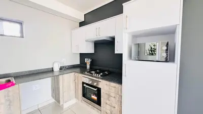 a kitchen with white cabinets and a stove at Rachels Haven in Boschrand