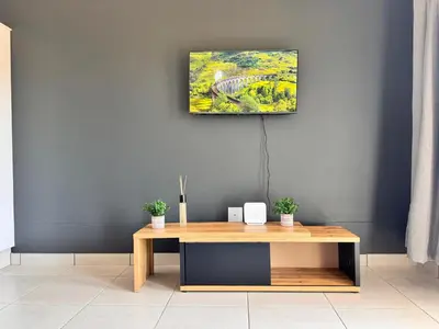 a living room with a table and a painting on the wall at Rachels Haven in Boschrand