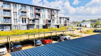 a parking lot with cars parked in front of a building at Rachels Haven in Boschrand