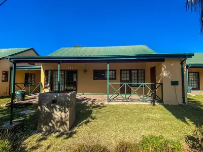 a building with a green roof and a yard at Pandleberry in Warmbaths