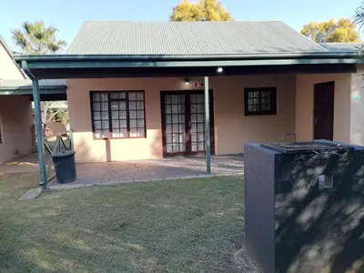 a small house with a trash can in front of it at Pandleberry in Warmbaths