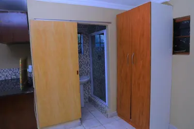 a bathroom with a wooden cabinet and a sink at Ivy at 6 Peace Sleep in Pretoria