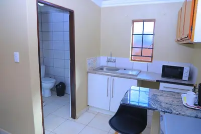 a small kitchen with a sink and a toilet at Ivy at 6 Peace Sleep in Pretoria