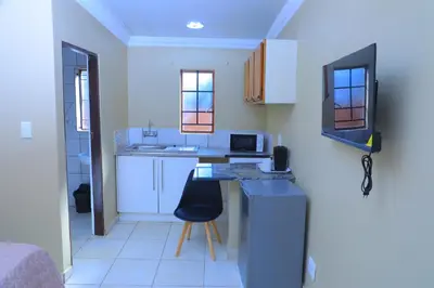 a small kitchen with a counter and a chair at Ivy at 6 Peace Sleep in Pretoria