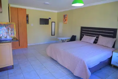 a bedroom with a large bed in a room at Ivy at 6 Peace Sleep in Pretoria