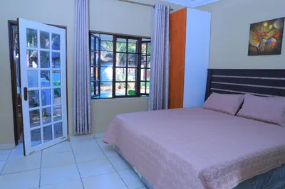 a bedroom with a bed and a large window at Ivy at 6 Peace Sleep in Pretoria