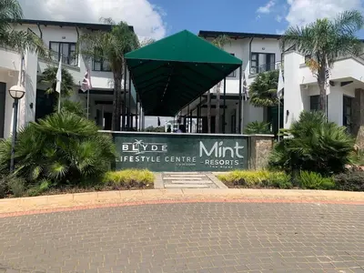 a sign in front of a building with a green umbrella at The Blyde Siesta in Pretoria