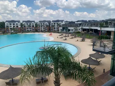a large swimming pool with umbrellas and a resort at The Blyde Siesta in Pretoria