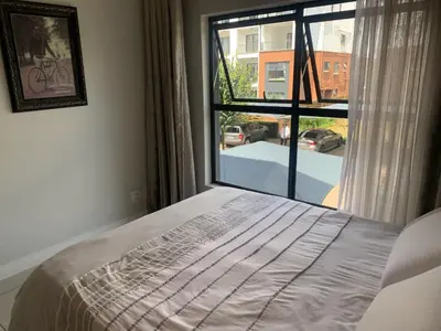 a bedroom with a bed and a large window at The Blyde Siesta in Pretoria