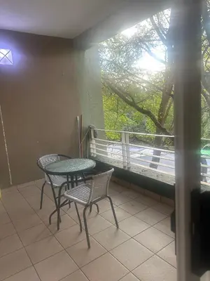 a patio with a table and chairs and a balcony at Bytes - Waterberry Mbombela in Nelspruit