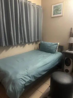 a bed in a room with a window and a chair at Bytes - Waterberry Mbombela in Nelspruit