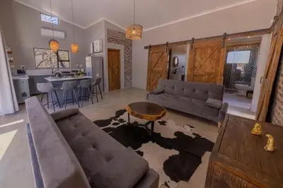 a living room with a couch and a table at Chui House A Bush Retreat with Pool and AC Near Kruger Gate in Marloth Park
