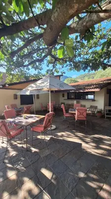 a patio with tables and chairs and an umbrella at Klipspringer Lodge in Nelspruit
