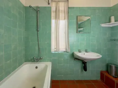 a green tiled bathroom with a sink and a tub at Park Gables Loftus Guest House in Pretoria