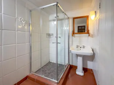 a bathroom with a shower and a sink at Park Gables Loftus Guest House in Pretoria