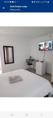 a picture of a room with a bed and a tv at Zindi Zindiza Lodge in Sandrivier