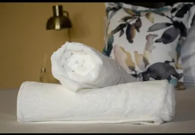 a roll of white towels sitting on a table at Private Room Kosmosdal in Centurion