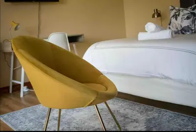 a yellow chair in a bedroom next to a bed at Private Room Kosmosdal in Centurion