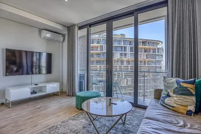 a living room with a couch and a large window at Celestial Cassini Cove at The Ellipse in Midrand