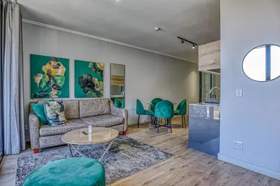 a living room with a couch and a table at Celestial Cassini Cove at The Ellipse in Midrand