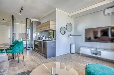 a kitchen with a table and some green chairs at Celestial Cassini Cove at The Ellipse in Midrand