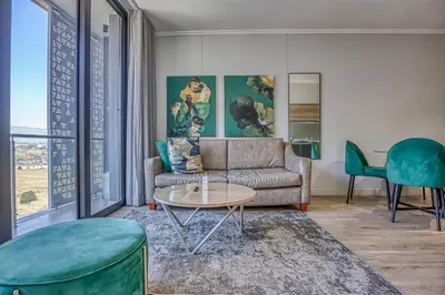 a living room with a couch and a table at Celestial Cassini Cove at The Ellipse in Midrand