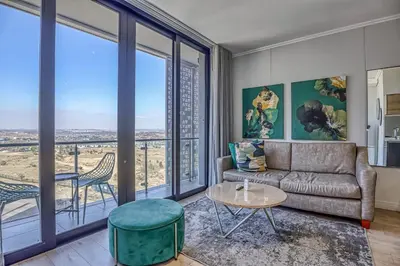 a living room with a couch and a table at Celestial Cassini Cove at The Ellipse in Midrand