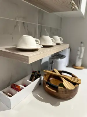 a kitchen with wooden shelves and bowls and utensils at Waterfall Luxury Apartment in Midrand