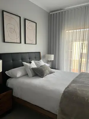 a bedroom with a large bed and a window at Waterfall Luxury Apartment in Midrand