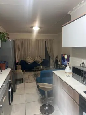 a kitchen and living room with a blue couch at The Blyde Estate Pretoria in Pretoria