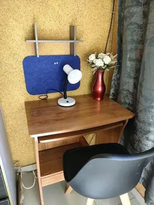 a desk with a chair and a vase with flowers at Siba's Place in Ga-Rankuwa