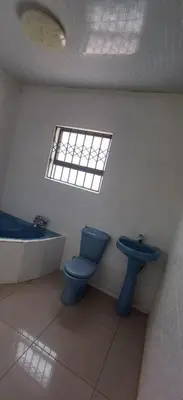 a bathroom with a blue toilet and a sink at Siba's Place in Ga-Rankuwa