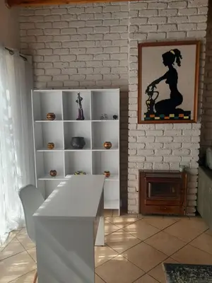 a living room with a white shelf and a fireplace at TANS - 1 bedroom luxury & cosy home walking distance to Doringkloof Mall in Centurion